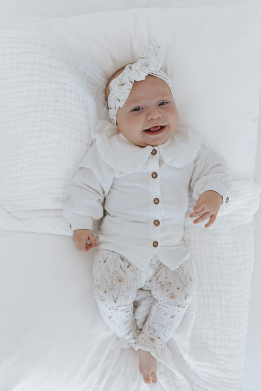 lachende baby in off white outfit