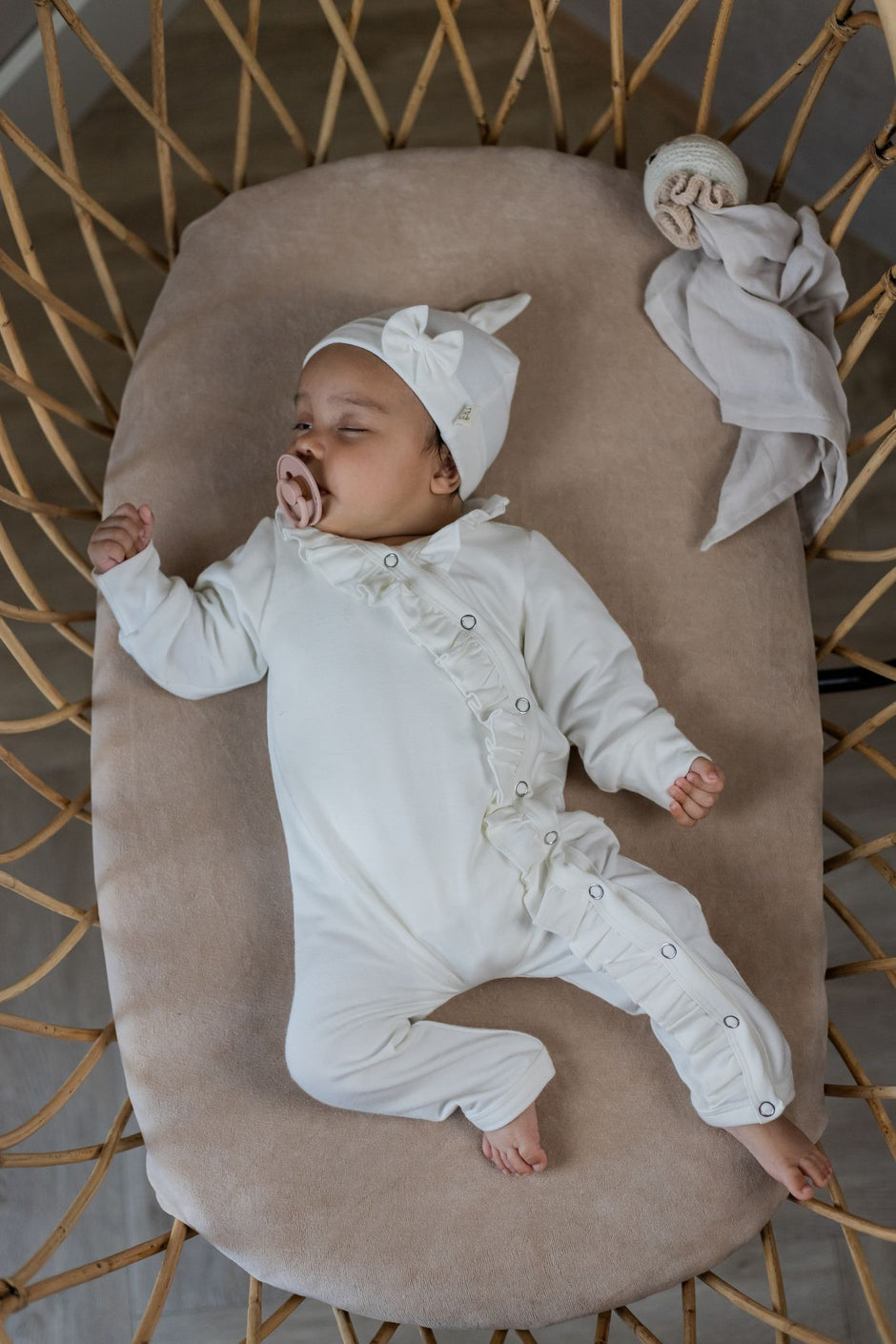 Slapende baby in off white outfit